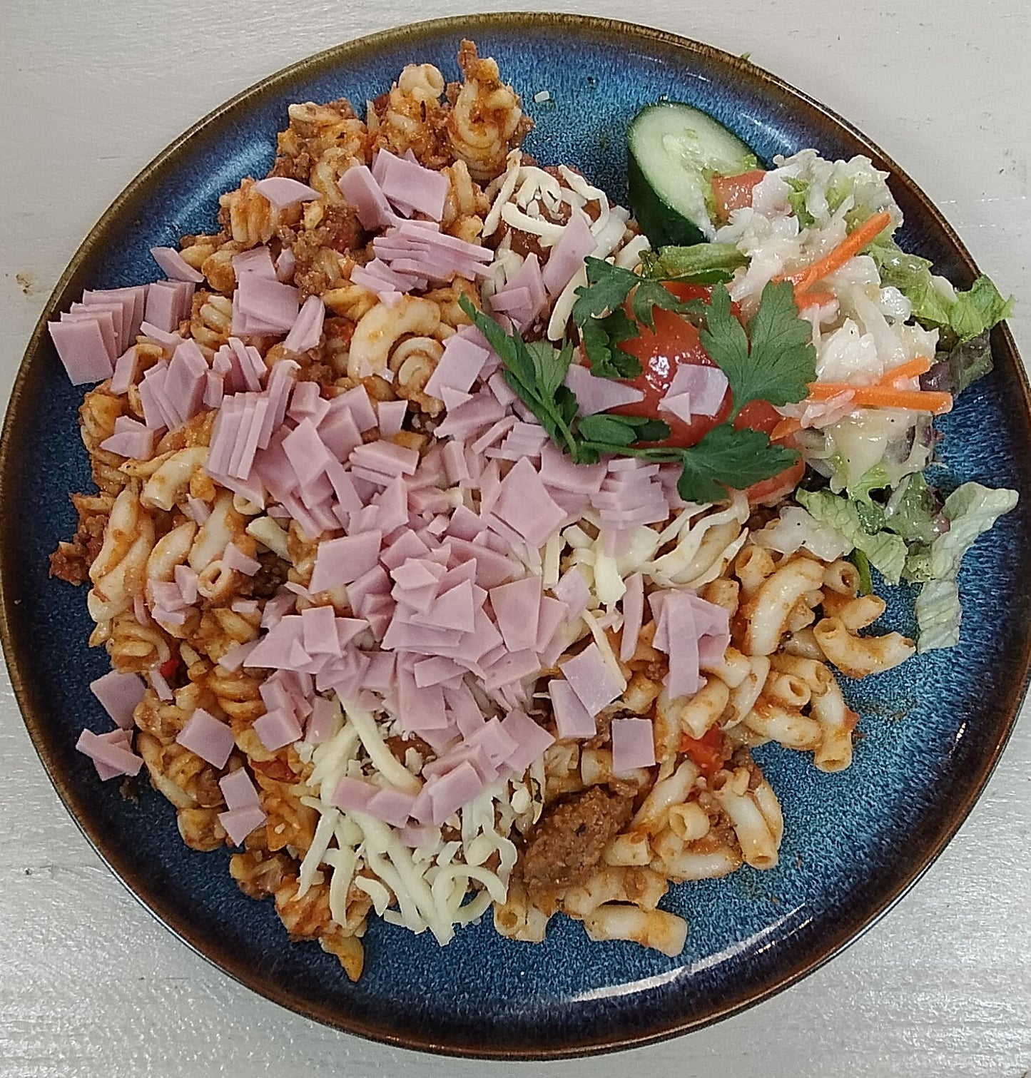 Pasta schotel Italienne (gehakt, ham, kaas, groente, saus), rauwkost